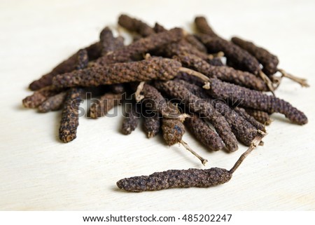 Long black pepper (Also called as Pipli in Indian, capsicum frutescens, Balinese pepper, Jaborandi pepper, Bengal pepper, Dipli in Thai, Piper longum) with mortar isolated on wood