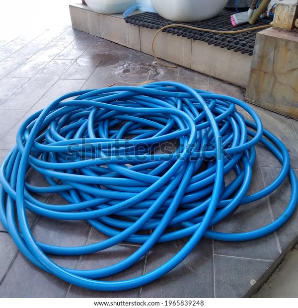 long blue water hose in the\
floor