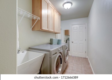 Long Bright Laundry Room Interior With Washer And Dryer And Birch Tree Wood Cabinets.