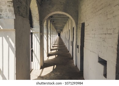 Long Corridor In Cellular Jail, Port Blair, Andaman Islands, India. Solitary Confinement Cells Along The White Wall Of An Old Prison.  January 11, 2018.