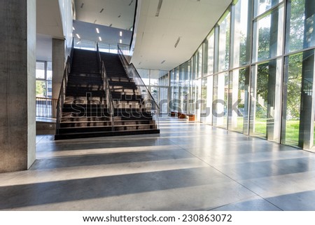 an long corridor in large building with stairs and glass