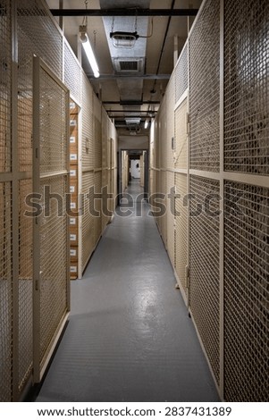 Long corridor lined with secure mesh cages inside the Bundesbank Bunker Cochem, a Cold War underground museum in Germany.