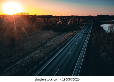 Long country road with white lines down the centre stretching off past a lone tree to the distant horizon - Powered by Shutterstock