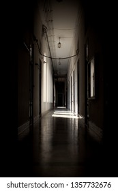 Long Dark School Hallway With Ligh Shining In Through A Series Of Arched Windows.  Taken In Thailand.