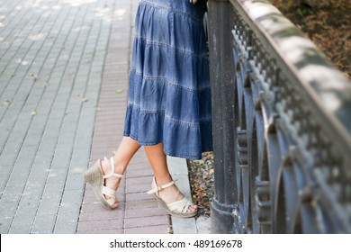 A Long Denim Skirt And Women's Legs.