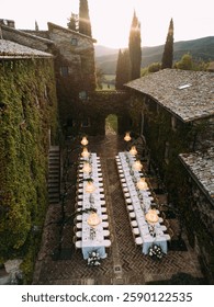 The long dining table, adorned with elegant white table settings and floral arrangements, creates a luxurious and intimate atmosphere.