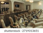Long dining table elegantly set with food, drinks, and floral decorations for a wedding reception or formal event