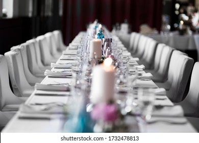 Long Dinner Table White Tablecloth Candle Like Wedding Table Decoration. Event Location In A Restaurant. 