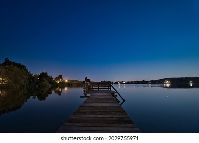 A Long Dock Going Out Into The Lake On A Summer Night Day In Klostersee, Seeon