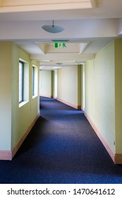 long empty corridor with an emergency exit sign