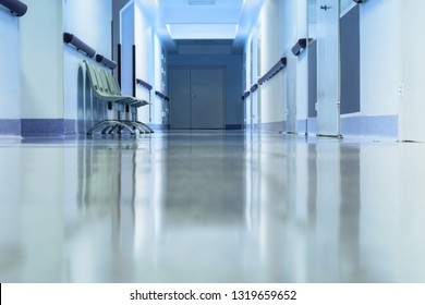 Long empty hallway with chairs in hospital. Tinted picture.