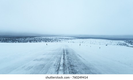 long empty road in white cold winter landscape