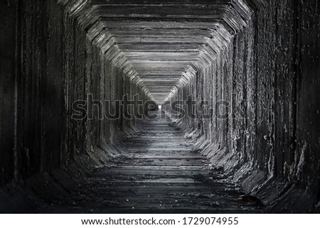 Long empty square concrete tunnel . Dried culvert.