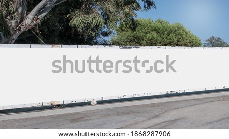 Long empty white hoarding with mock up place at city street. Industrial concept.