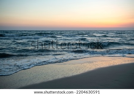 Long exposure by the sea. Waves break against stones. Sunset at the beach. Long exposure at night by the sea. Patara Beach Antalya Turkey