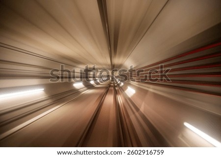 Long exposure captures the dramatic motion of a metro train moving through a tunnel. Bright lights and blurred lines create a sense of speed and depth in the underground transit system.