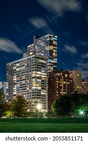 Long Exposure Of Clouds Moving Across A Dark Blue Sky Over Modern Residential Highrise Buildings In The Lakeview Neighborhood Along Lake Shore Drive In Chicago At Night.