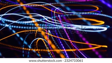 Long exposure colorful light painting photography, abstract background, curvy lines of vibrant neon metallic against a black background
