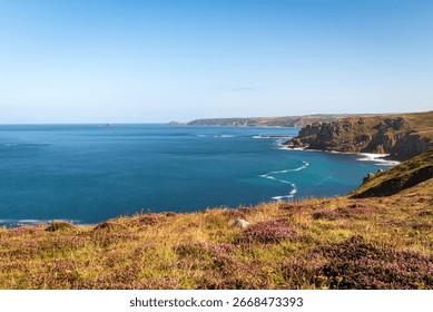 Long exposure of dramatic cliffs at Land's End, Cornwall. Smooth sea and textured rock formations create a serene and powerful coastal landscape.