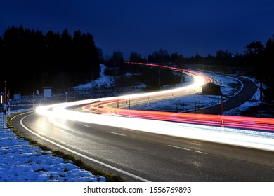 Long Exposure of driving cars on a curvy road in the black forest at snow (1) - Powered by Shutterstock