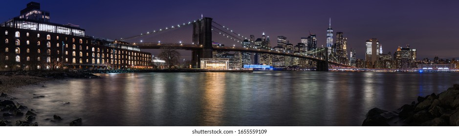Langer Kontakt mit hochauflösendem Panoramabild von Brooklyn Bridge und Downtown Manhattan mit glattem Wasser bei Nacht