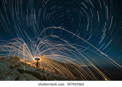 Long exposure image  showing star trails over medieval fortress Enisala and steel whool photography, light painting in the night.