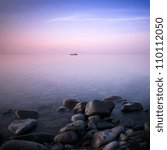 The long exposure image shows the fishing Ship on the water and made the stones adding calm. Crimea, Ukraine