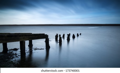 Long Exposure Landscape Of Old Jetty Extending Into Lake