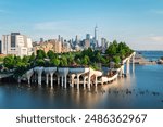 Long exposure of Little Island over the Hudson River in Chelsea, New York, with the lower Manhattan skyline as a stunning backdrop at dusk.