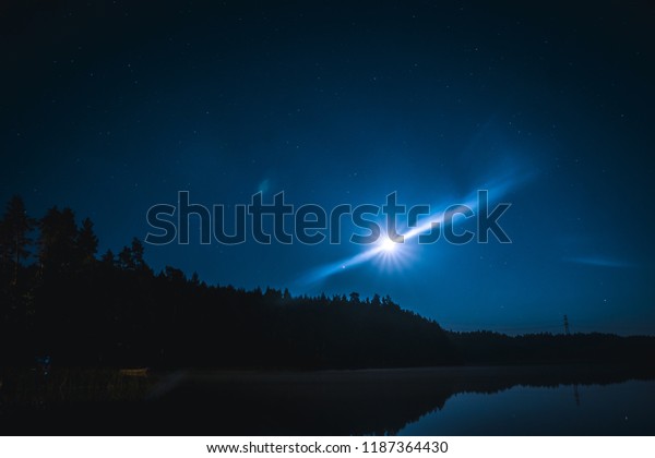 Long exposure moon\
and stars above the lake