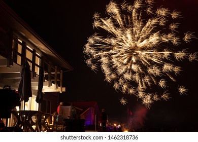 Long Exposure Of A Mortar Shell Firework Exploding Over A Residential Backyard