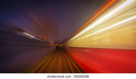 A Long Exposure Motion Blur Of A DLR Train Crossing A Tunnel In London, England, UK During Early Evening
