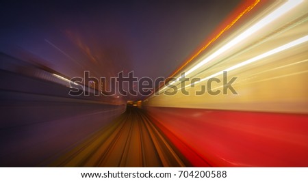 A long exposure motion blur of a DLR train crossing a tunnel in London, England, UK during early evening
