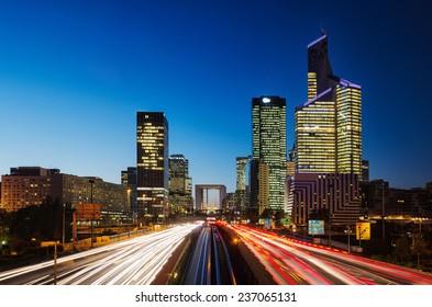 Long exposure of multi-lane road with skyscrapers of business district La Defense, Paris, France in the background