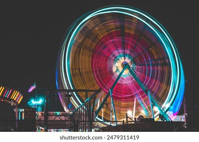 Long Exposure neon Ferris Wheel at a fair at night, amusement park, carnival - Powered by Shutterstock