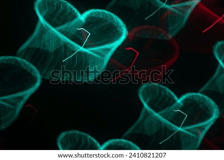 Long exposure neon hearts. Projection of laser light on the wall	
