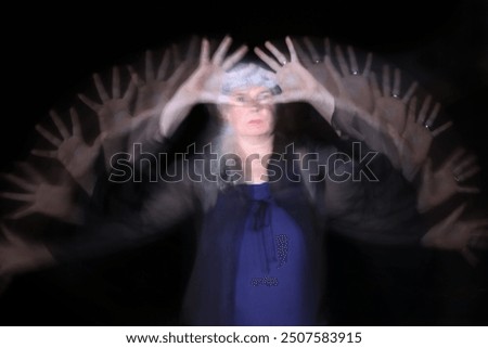 Long exposure at night of a woman waving her hands. What a pity that you stop here!