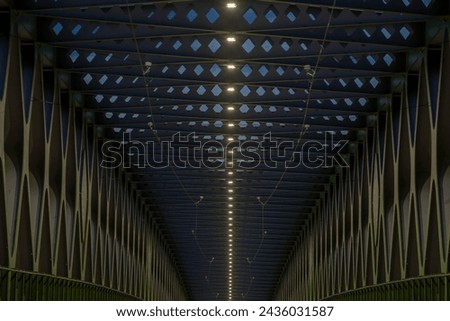 A long exposure of a pedestrian bridge over a river at night. The old bridge. Bratislava, Slovakia. Perspective view.