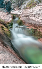 Long exposure photo of a small waterfall of the Flumineddu stream just outside the famous and suggestive gorroppu canyon. The water colors and the wild setting make this place a paradise for hikers - Shutterstock ID 2310742539