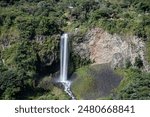 long exposure photograph capturing the Manto de la Novia waterfall in Baños de Agua Santa, Tungurahua province, Ecuador. beautifully shows silky smooth flow of water cascading down the rocky cliffs