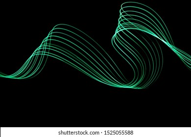 Long Exposure Photograph Of Neon Green Colour In An Abstract Swirl, Parallel Lines Pattern Against A Black Background. Light Painting Photography.