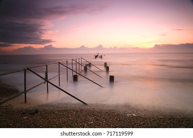 A long exposure photograph of a sunrise over the beach at Lowestoft, England’s most easterly point using a 10-stop filter to smooth out the water and sky - Shutterstock ID 717119599