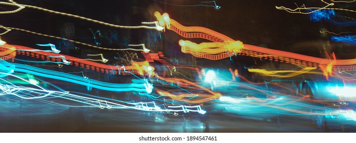 Long Exposure Photography. Defocused Photography Of Moscow Cityscape In Night Time. Big Traffic. Street Is Filled By Cars. Blurred Motion Of Cable Car. Yellow, Red, Brown, Black Colors