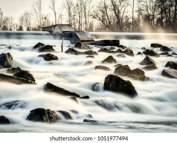 long exposure of a river with rocks and a dam - Powered by Shutterstock