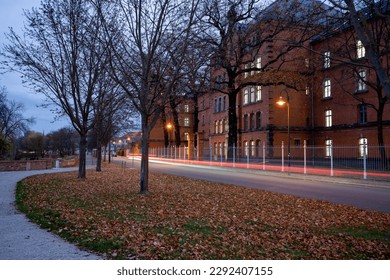 Long exposure of road between small park and building