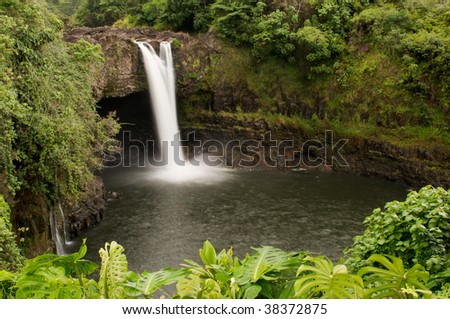 Long exposure of scenic Rainbow Falls of the Wailuku River, nestled among the lush green rainforest, near Hilo, Hawaii