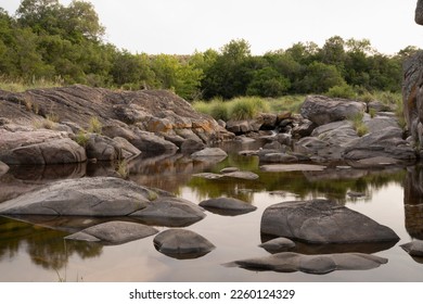 Long exposure shot of the calm river with a rocky shore in the forest at sunset.	 - Powered by Shutterstock