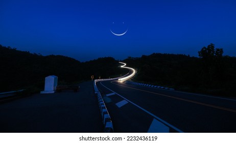 Long exposure shot  car light twilight time and blue sky the moon background, at Curved Road No.3 or Route No.1081 over top of mountains in Santisuk - Bo Kluea District, Nan province, Thailand.
 - Shutterstock ID 2232436119
