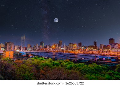 Long Exposure Shot Of Johannesburg City Skyline And Nelson Mandela Bridge At Night With Moon And Galaxy