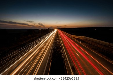 A long exposure shot of red and yellow car lights on a highway in the evening - Powered by Shutterstock